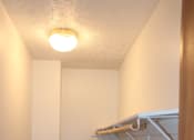 Thumbnail 10 of 13 - A hallway with a carpeted floor and a light on the ceiling.