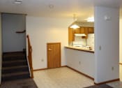 Thumbnail 6 of 13 - A kitchen area with a staircase leading to the upper floor.