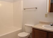 Thumbnail 11 of 13 - A white toilet sits next to a bathtub in a bathroom.