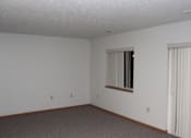 Thumbnail 9 of 13 - A room with a window and a carpeted floor.