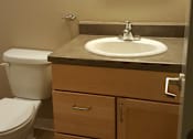 Thumbnail 4 of 5 - A bathroom with a toilet, sink, and mirror.