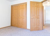 Thumbnail 15 of 19 - Two wooden doors in a room with carpeted floor.