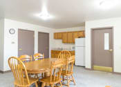 Thumbnail 5 of 19 - A dining room with a table and chairs.