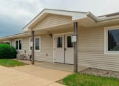 Thumbnail 1 of 19 - A house with a grey siding and a white door.