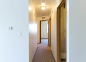 Thumbnail 14 of 19 - A hallway with a carpeted floor and white walls.