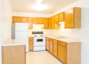 Thumbnail 10 of 19 - A kitchen with wooden cabinets and white appliances.