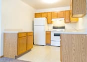 Thumbnail 9 of 19 - A kitchen with wooden cabinets and a white refrigerator.
