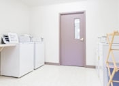Thumbnail 19 of 19 - A room with a purple door, white cabinets, and a printer on top of the cabinets.