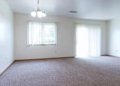 Thumbnail 12 of 19 - A room with a carpeted floor and a window with blinds.