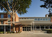Thumbnail 1 of 28 - a large brick building with a large tree in front of it