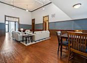 Thumbnail 6 of 25 - A living room with a white couch and a wooden table.