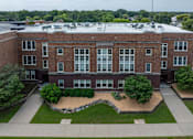 Thumbnail 17 of 17 - A red brick building with a landscaped front yard.