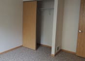 Thumbnail 8 of 11 - A room with a carpeted floor and a wooden door.