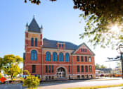 Thumbnail 1 of 25 - Roosevelt School is a two story brick building with large historic windows and a tower in the northeast corner of the building.