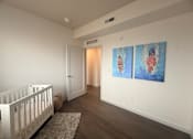 Thumbnail 10 of 14 - A baby's room with a white crib and two paintings on the wall.