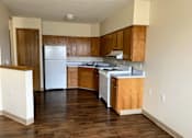 Thumbnail 15 of 21 - an empty kitchen with white appliances and wooden cabinets