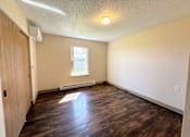 Thumbnail 10 of 21 - an empty living room with wood flooring and a window