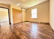 Thumbnail 11 of 21 - an empty living room with wood flooring and a door
