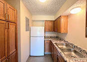 Thumbnail 3 of 21 - a kitchen with a refrigerator and sink and wooden cabinets