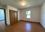 Thumbnail 7 of 21 - an empty living room with wood flooring and a window