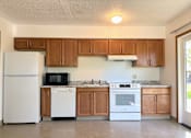 Thumbnail 1 of 21 - an empty kitchen with white appliances and wooden cabinets