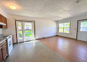 Thumbnail 6 of 21 - an empty kitchen and living room with a door to the yard