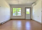 Thumbnail 4 of 21 - an empty living room with wood floors and a window