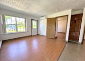 Thumbnail 5 of 21 - an empty living room with wood flooring and a window