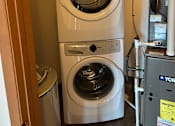 Thumbnail 8 of 12 - Two front loading washing machines in a laundry room.