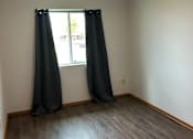 Thumbnail 6 of 12 - A window with black blinds in a room with a wooden wall.