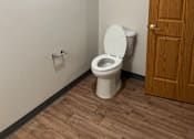 Thumbnail 11 of 12 - A white toilet with a wooden cabinet above it.