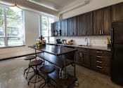 Thumbnail 5 of 22 - A kitchen with a table and chairs in front of a window.
