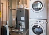 Thumbnail 13 of 22 - A washing machine is on top of a dryer in a utility room.