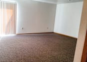 Thumbnail 5 of 12 - A room with a carpeted floor and a large window with blinds.