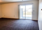 Thumbnail 4 of 12 - A room with a carpeted floor and a sliding glass door.