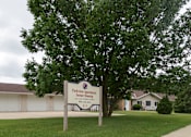 Thumbnail 1 of 12 - A sign for Parkview Apartments Senior Housing stands in front of a building.
