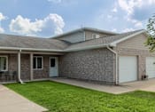 Thumbnail 1 of 16 - A house with a grey roof and a white garage door.