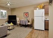 Thumbnail 7 of 14 - our apartments offer a living room with a couch a dining table and a refrigerator