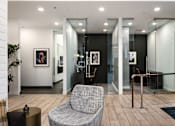 Thumbnail 15 of 22 - A grey chair sits in a room with a glass wall.