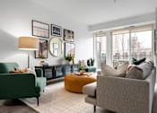 Thumbnail 3 of 22 - A living room with a green chair, a grey sofa, and a yellow ottoman.
