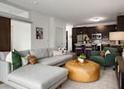 Thumbnail 7 of 22 - A modern living room with a grey sofa and a yellow ottoman.