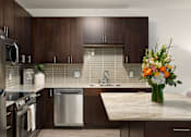 Thumbnail 2 of 22 - A kitchen with a stainless steel refrigerator, a dishwasher, and a sink.