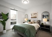 Thumbnail 8 of 22 - A bedroom with a bed, nightstand, and a plant.