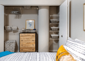 Thumbnail 10 of 25 - a closet in a bedroom with a bed and a dresser  at The Cosmopolitan, St Paul, Minnesota