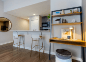 Thumbnail 5 of 25 - a bar area with three stools in front of a kitchen with a counter top  at The Cosmopolitan, St Paul, MN, 55101
