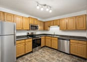 Thumbnail 4 of 45 - a kitchen with wooden cabinets and stainless steel appliances at Cityscape, Minnesota