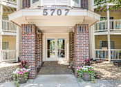 Thumbnail 41 of 45 - the front entrance of a condo building with flowers on the sidewalk at Cityscape, St Louis Park, MN