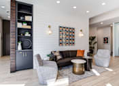 Thumbnail 13 of 22 - A modern living room with a grey sofa, a grey armchair, a black cabinet, and a wooden floor.