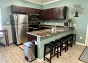 Thumbnail 6 of 14 - a kitchen with stainless steel appliances and a bar with stools at Shenandoah Properties in Lafayette, IN 47905