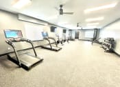 Thumbnail 3 of 14 - a large fitness room with treadmills and other exercise equipment at Murdock Gardens Apartments, Lafayette, IN 47904